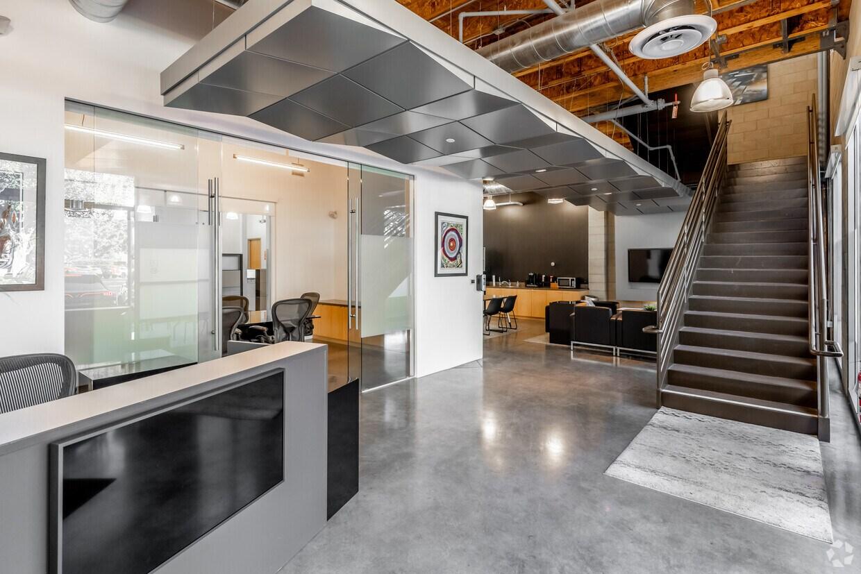 Premier Irvine Spectrum office amenities at 9930 Irvine Center Drive, featuring a modern lobby with high-volume ceilings and creative industrial design.