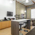 Modern second-floor employee breakroom and kitchenette with premium finishes.